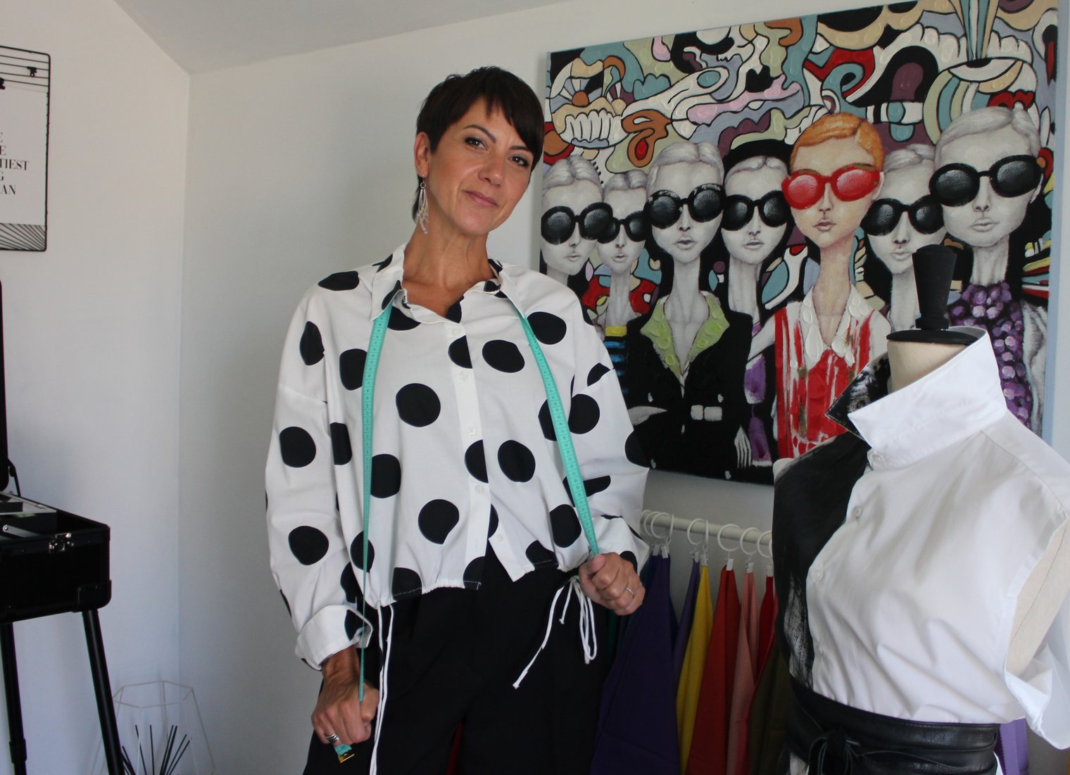 Audrey Fisicaro dans son atelier, devant le portant d'étoffes colorées